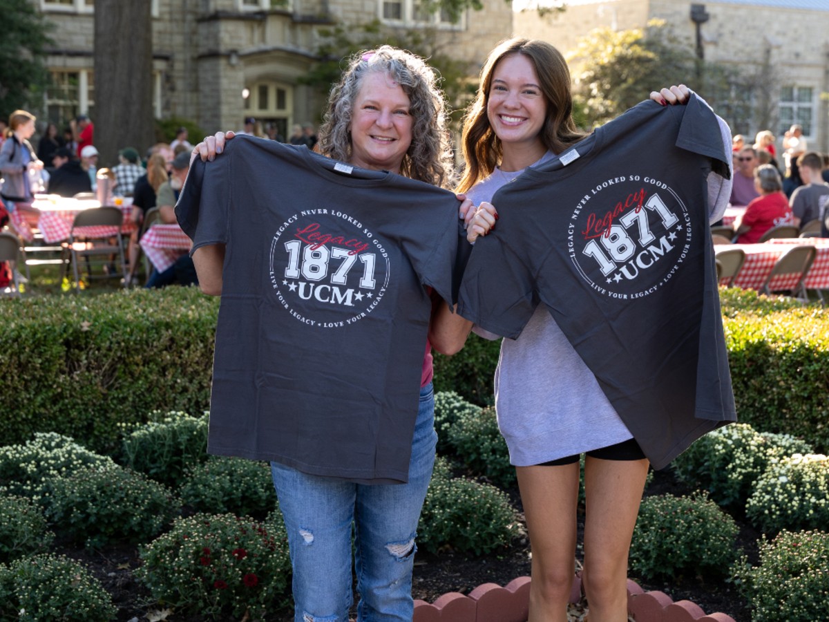 UCM Legacy Clothing Line Women holding UCM Legacy T-shirts