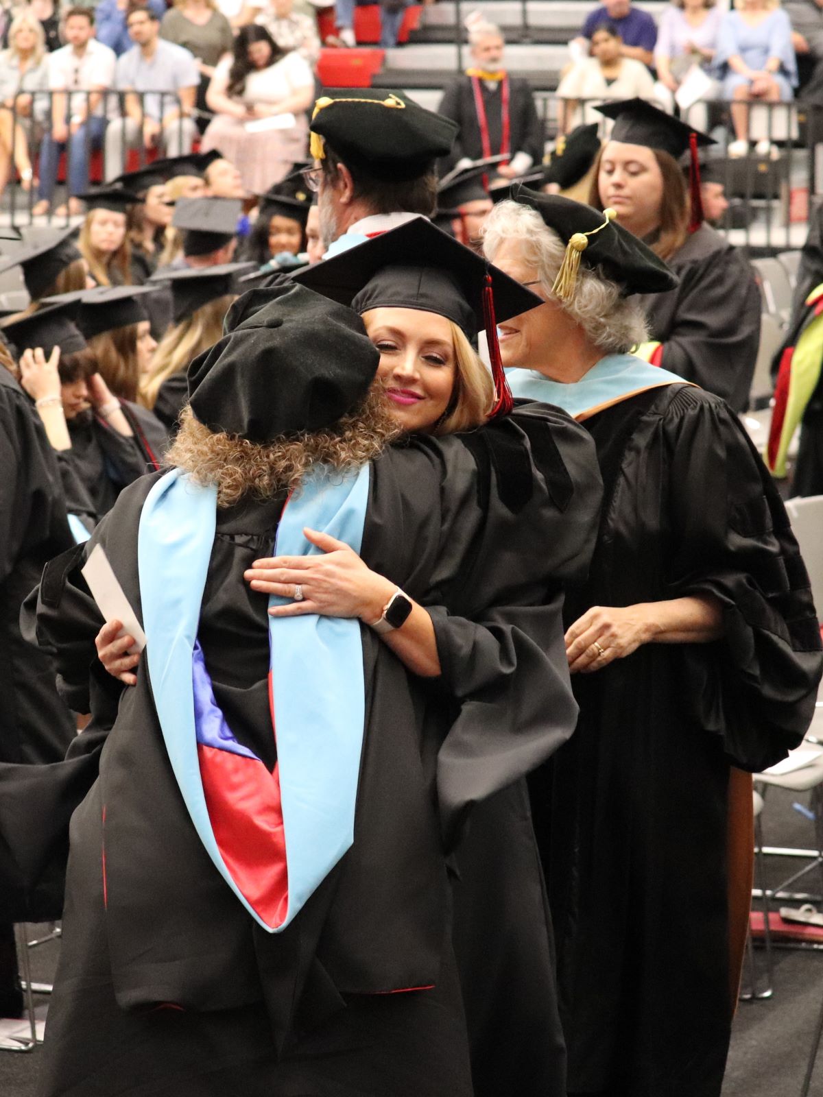 student hugging professor at commencement